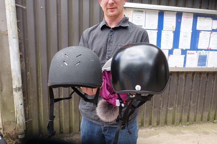 Росс Хед держит в руках шлем серийного производства (слева) и индивидуальный шлем Cerebra (справа)